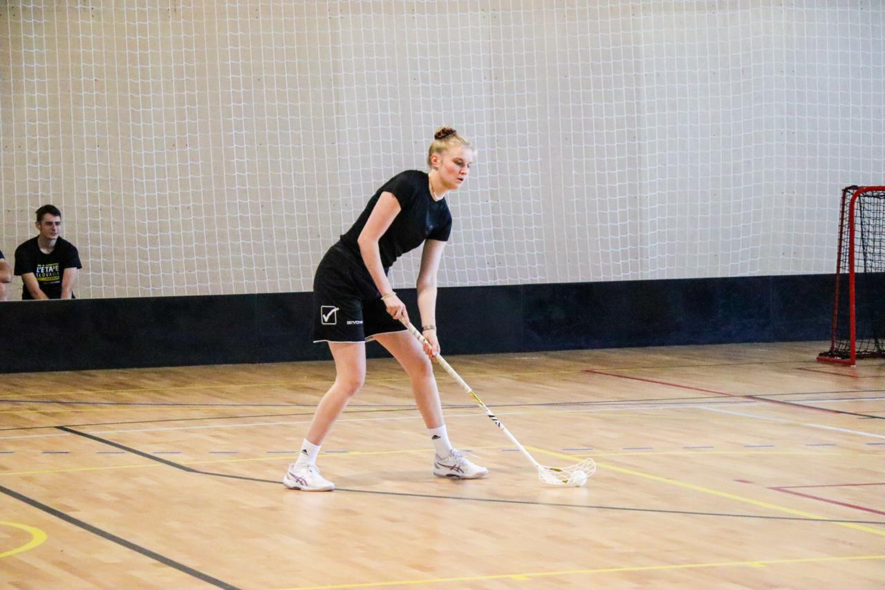 Hráčka rozohráva loptičku počas florbalového zápasu